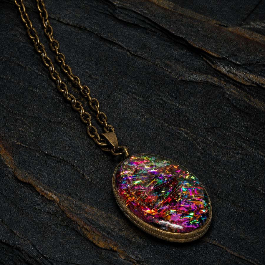 Aurora Fire oval pendant necklace with antique brass chain on dark stratified stone