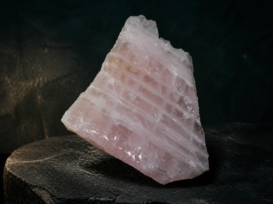 Close detail of the natural fracture texture and pink translucency of a rough rose quartz specimen