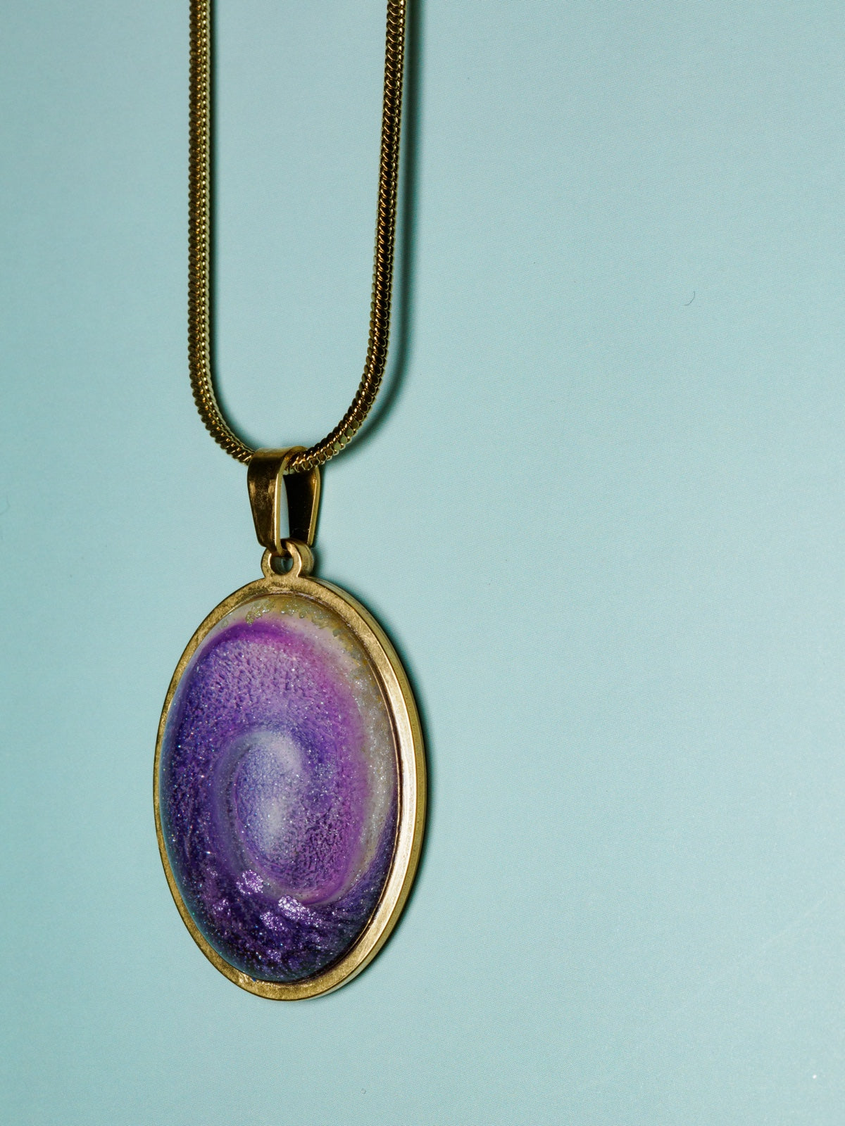 Purple resin dome pendant in an 18k gold plated oval bezel on a fine gold chain