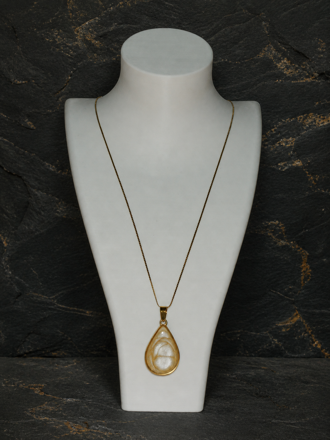 Ivory Strata 18K gold-plated teardrop pendant on a display bust