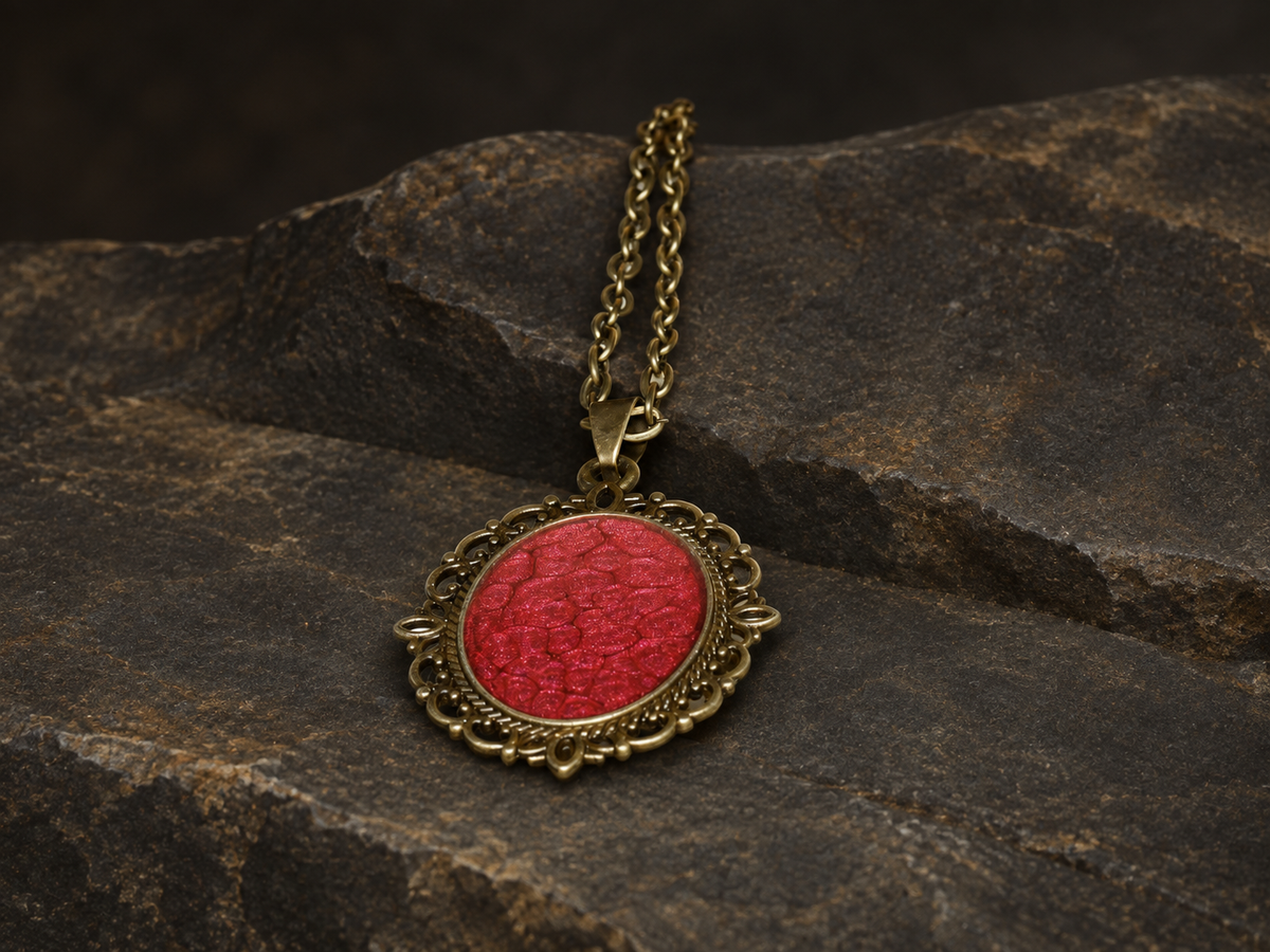 Ember Relic Filigree Pendant, red oval centre and antique gold filigree, detail view.