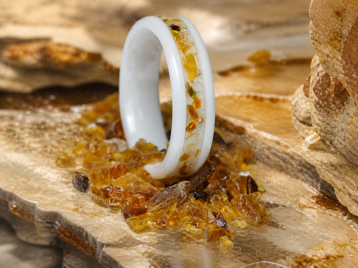 Resin of Time: Afterglow white ceramic ring standing among genuine amber fragments