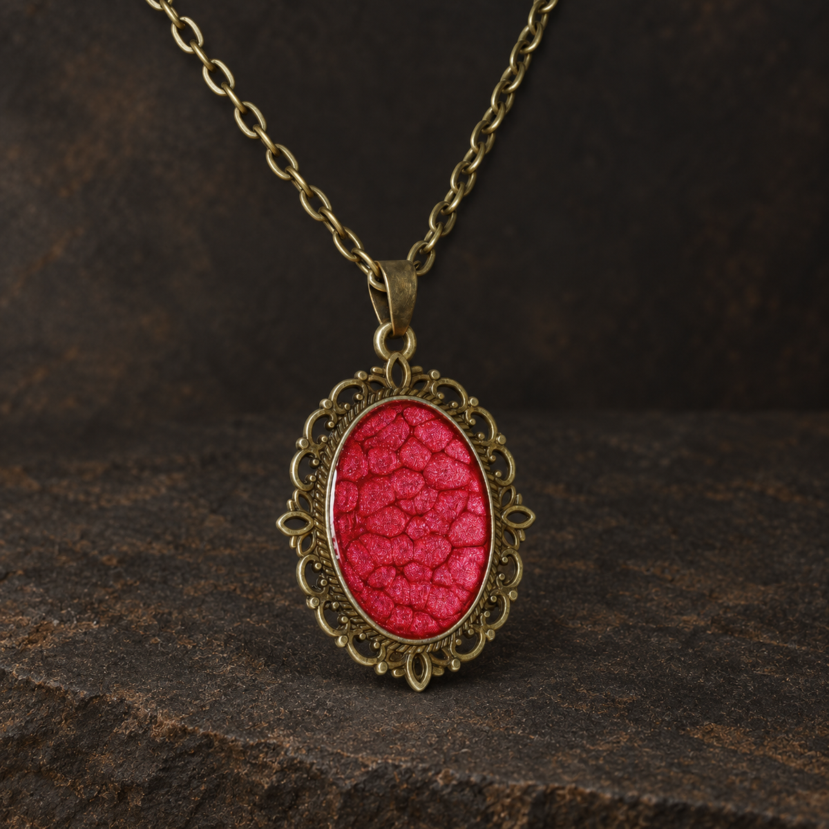 Ember Relic Filigree Pendant, front view showing the textured red oval centre and filigree setting.