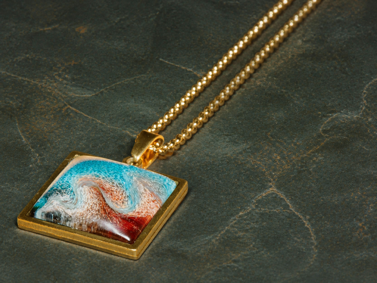 Diagonal detail view of the Tidal Fault pendant and gold-plated chain