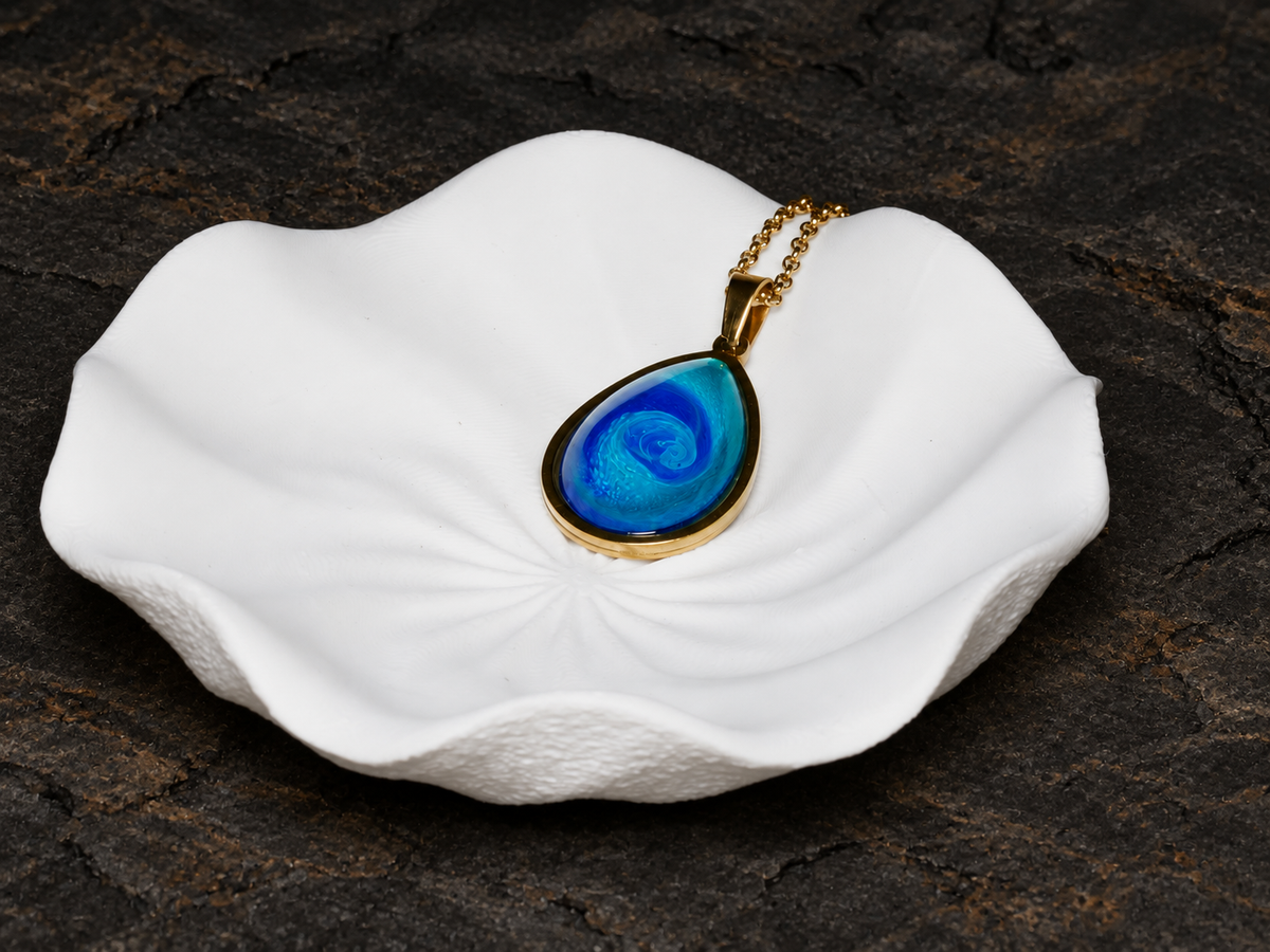 Abyssal Current teardrop pendant angled on a sculptural display