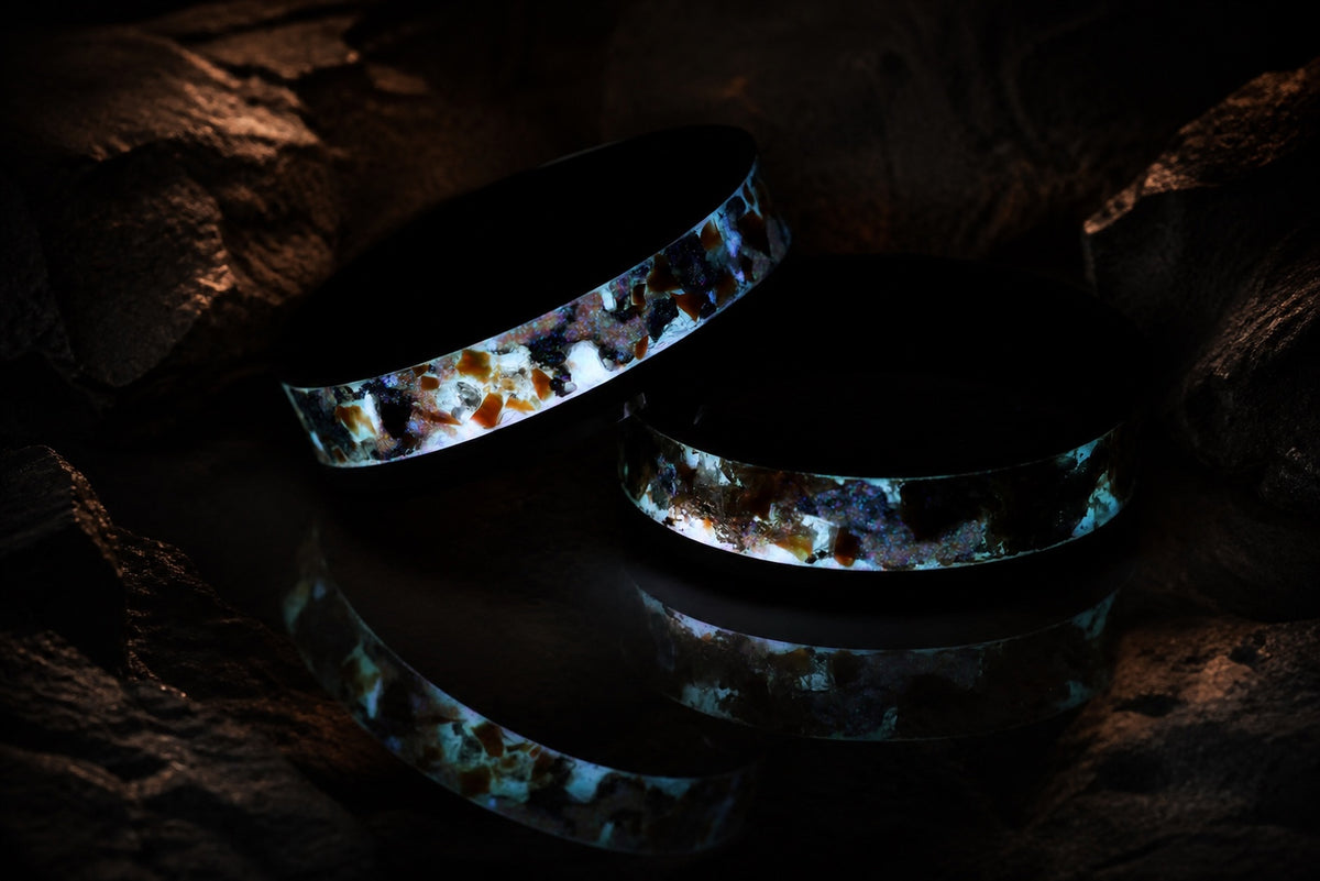 Long-exposure glow view of two Gilded Eventide rings with reflection