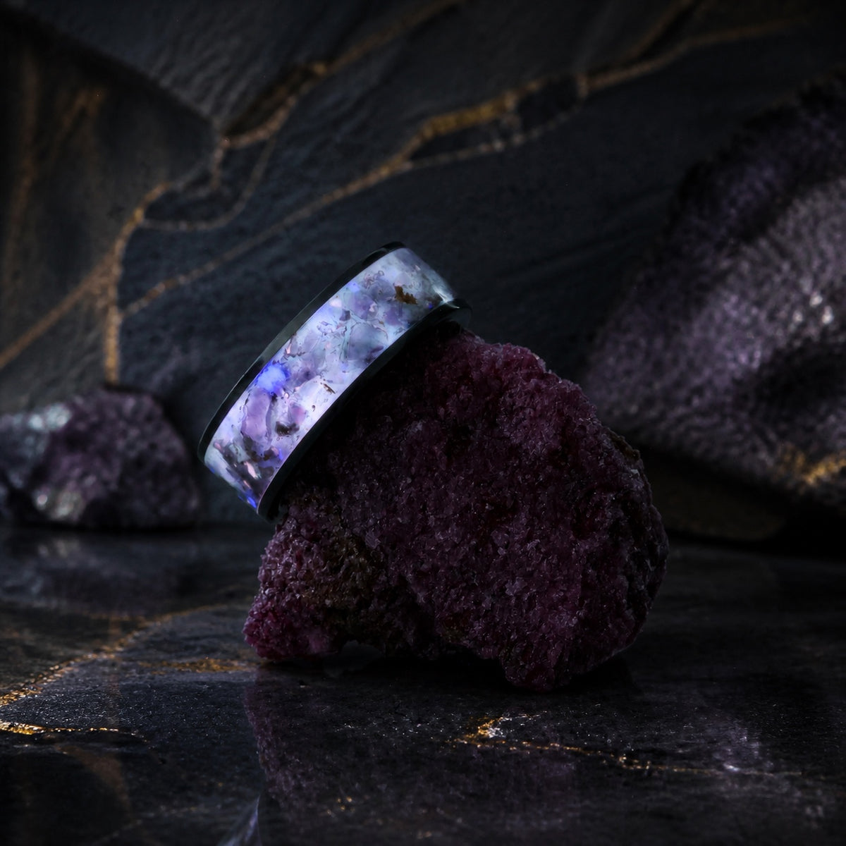 Star-Dust Amethyst ring balanced on a dark purple mineral specimen
