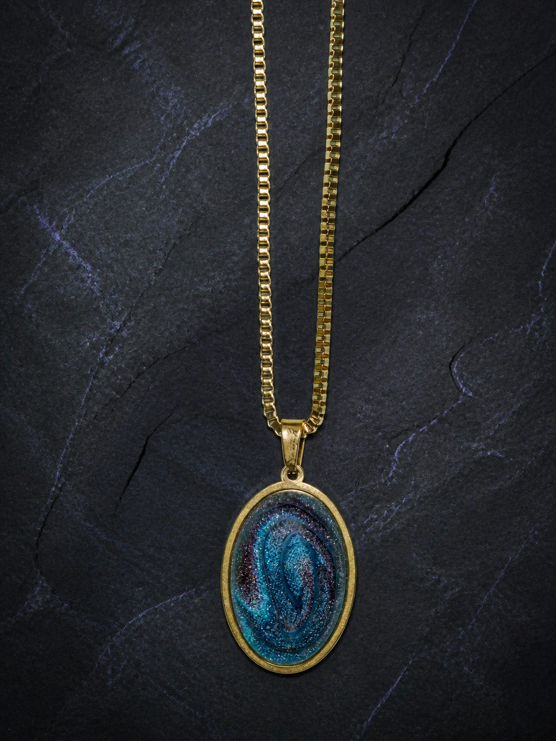 Abyssal Spiral oval pendant with blue-violet resin dome on a large gold box chain