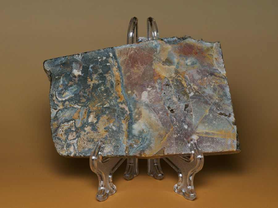 Brecciated jasper with agate slab displayed upright, showing slate blue, ochre and rust-red pattern.