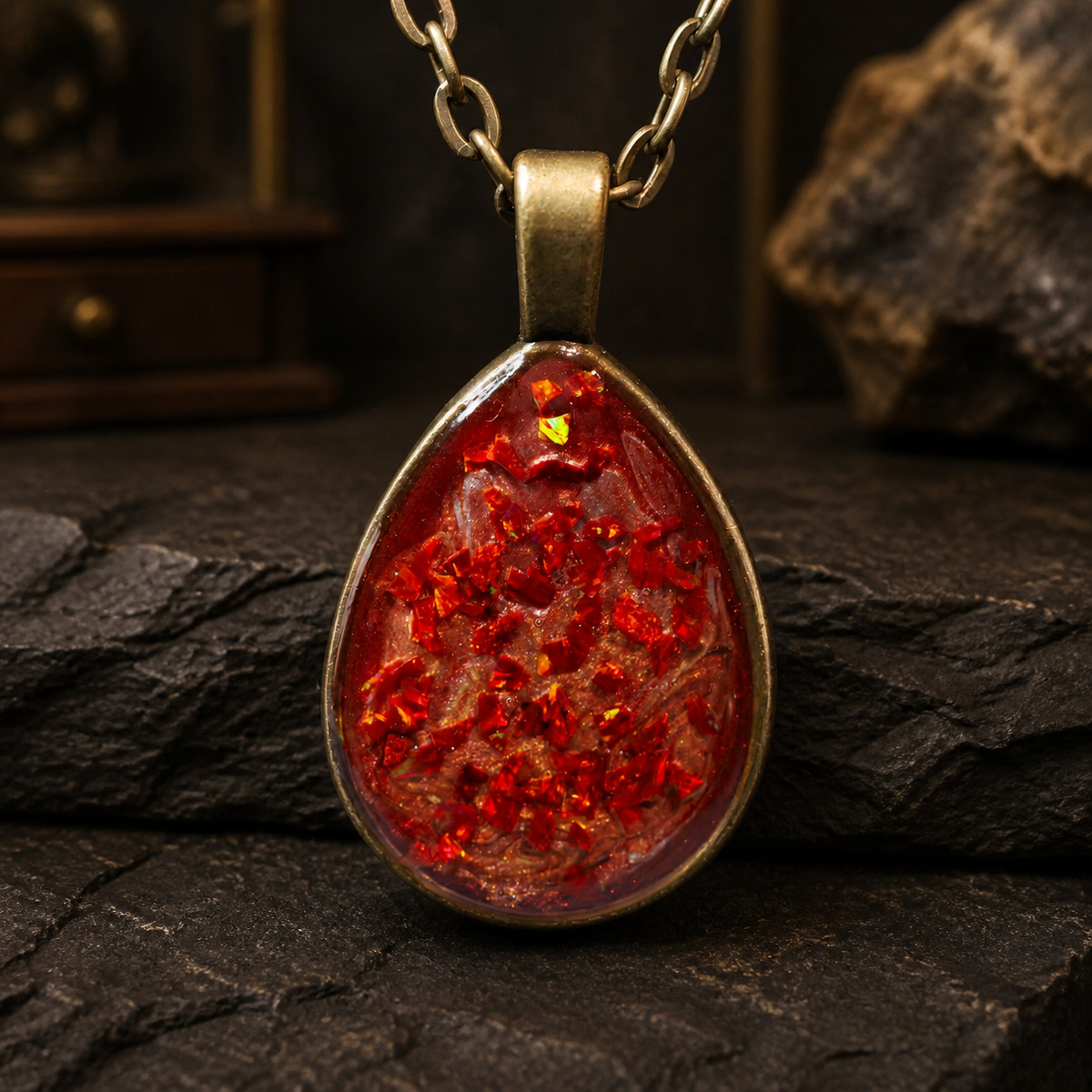 Close-up of the Cinderstrata pendant showing red, orange, gold and green flashes