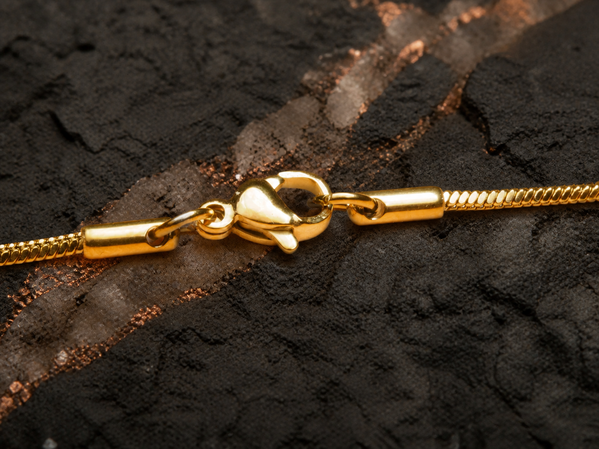 Gold-plated chain clasp on basalt with smoky quartz and copper mineral texture