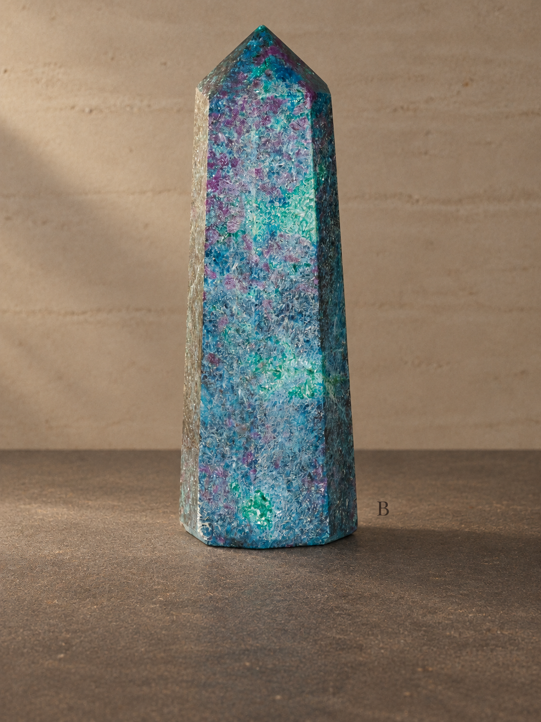 Ruby in kyanite obelisk B, 10 cm tall, labelled B against a neutral limestone gallery background