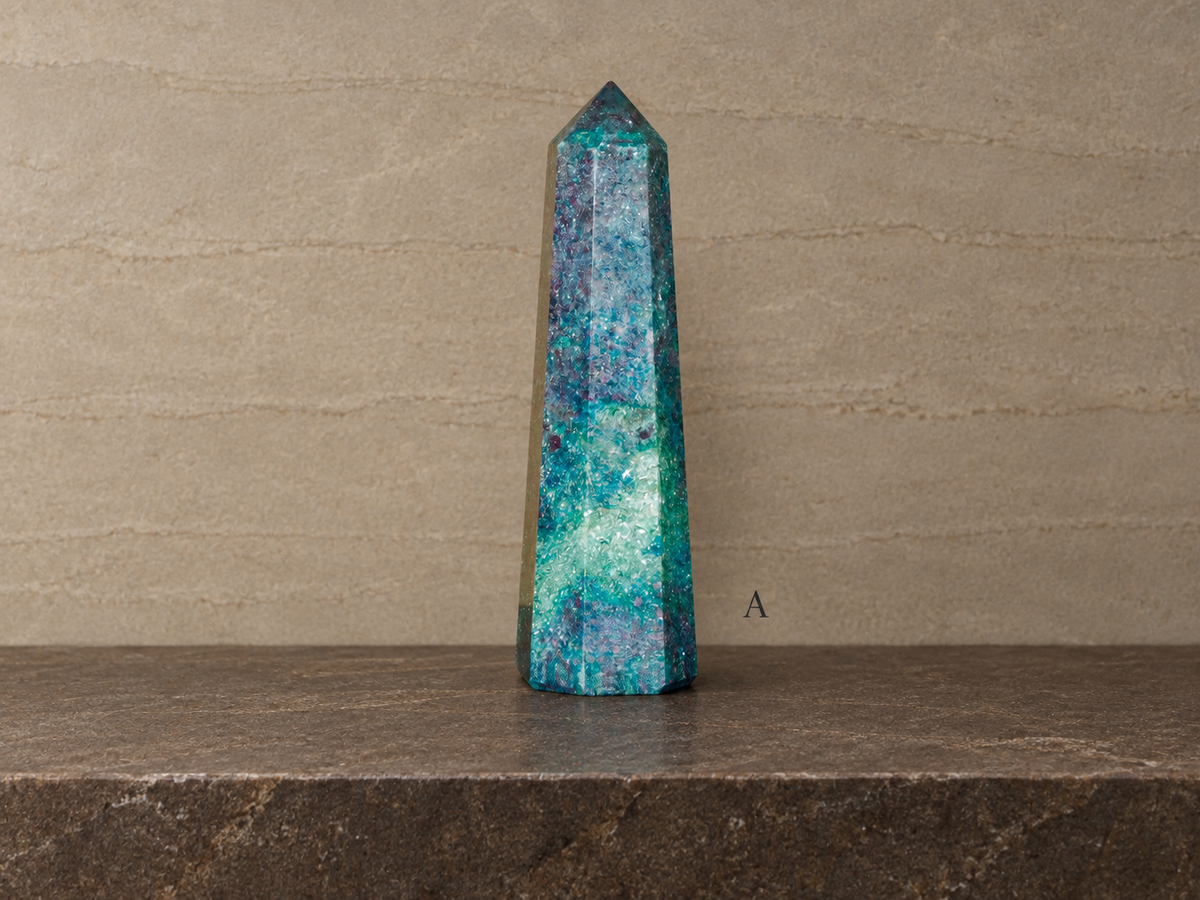 A ruby in kyanite obelisk in natural light, labelled A against a muted stratified gallery background