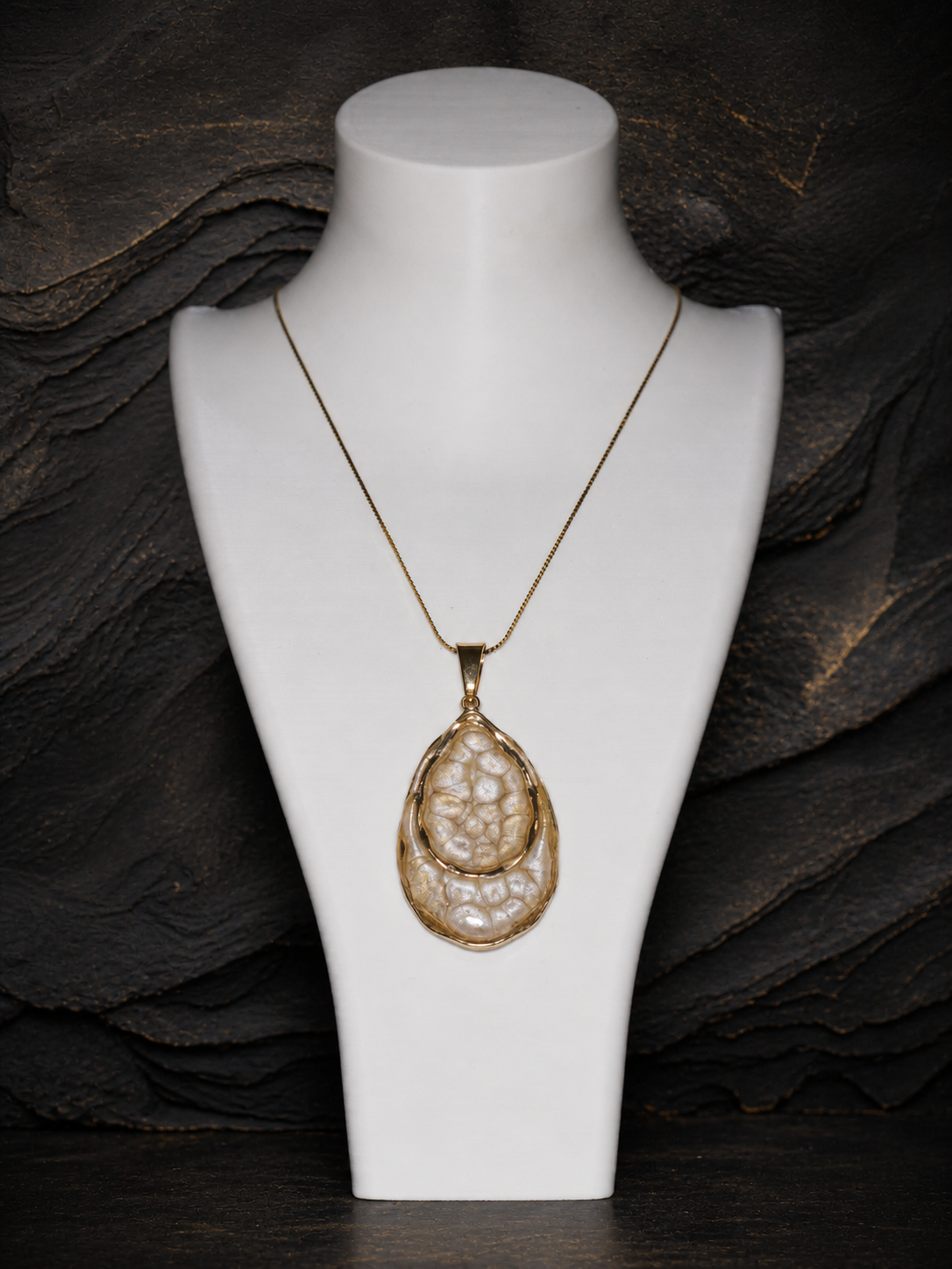 Earthlight Strata pendant and gold chain displayed on a jewellery bust