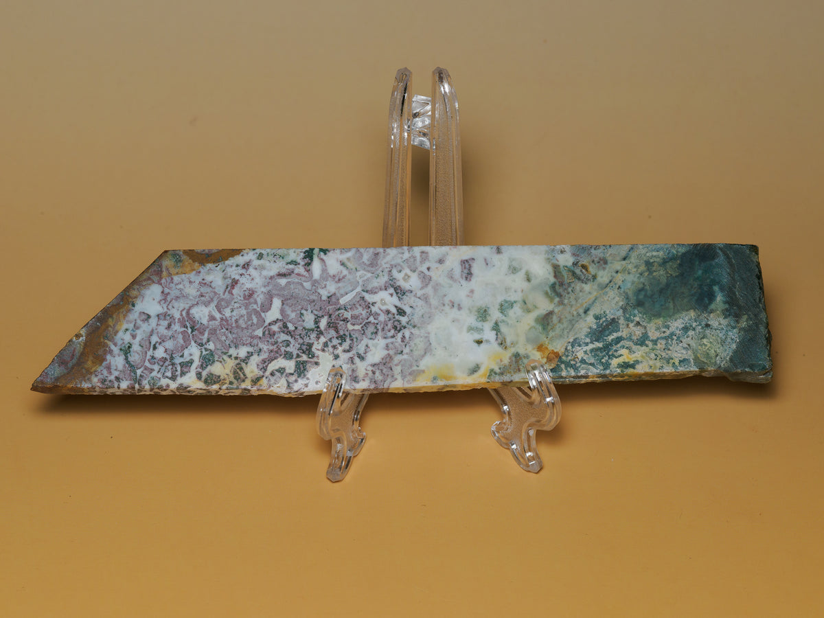 Reverse face of the East Java multicolour jasper slab on a clear display stand