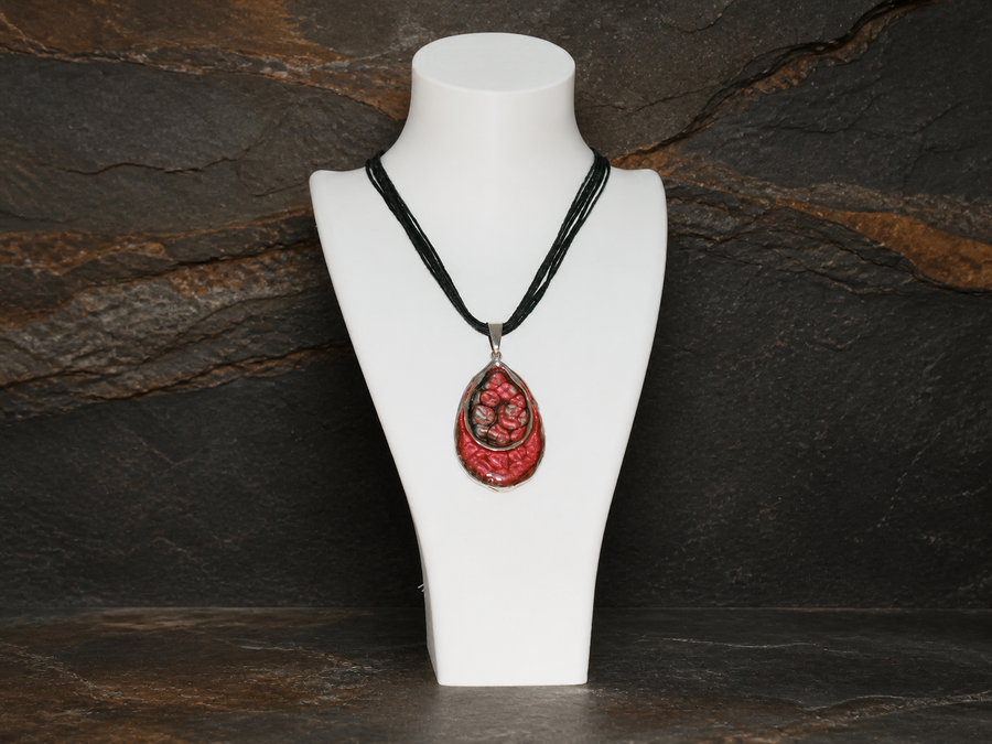 Ember Tide Double Teardrop Necklace on a white display bust against dark mineral stone