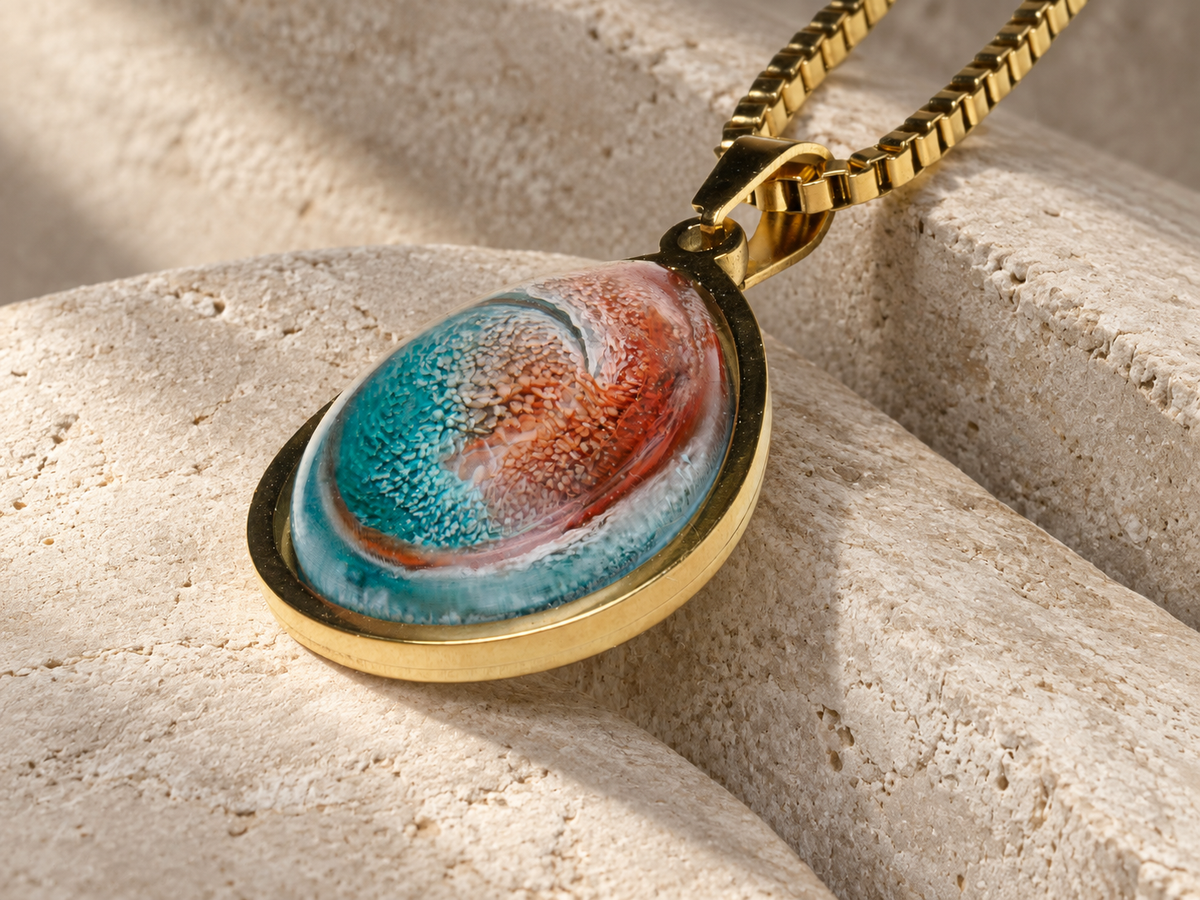 Close angled view of Ember Tide teardrop pendant and thick box chain