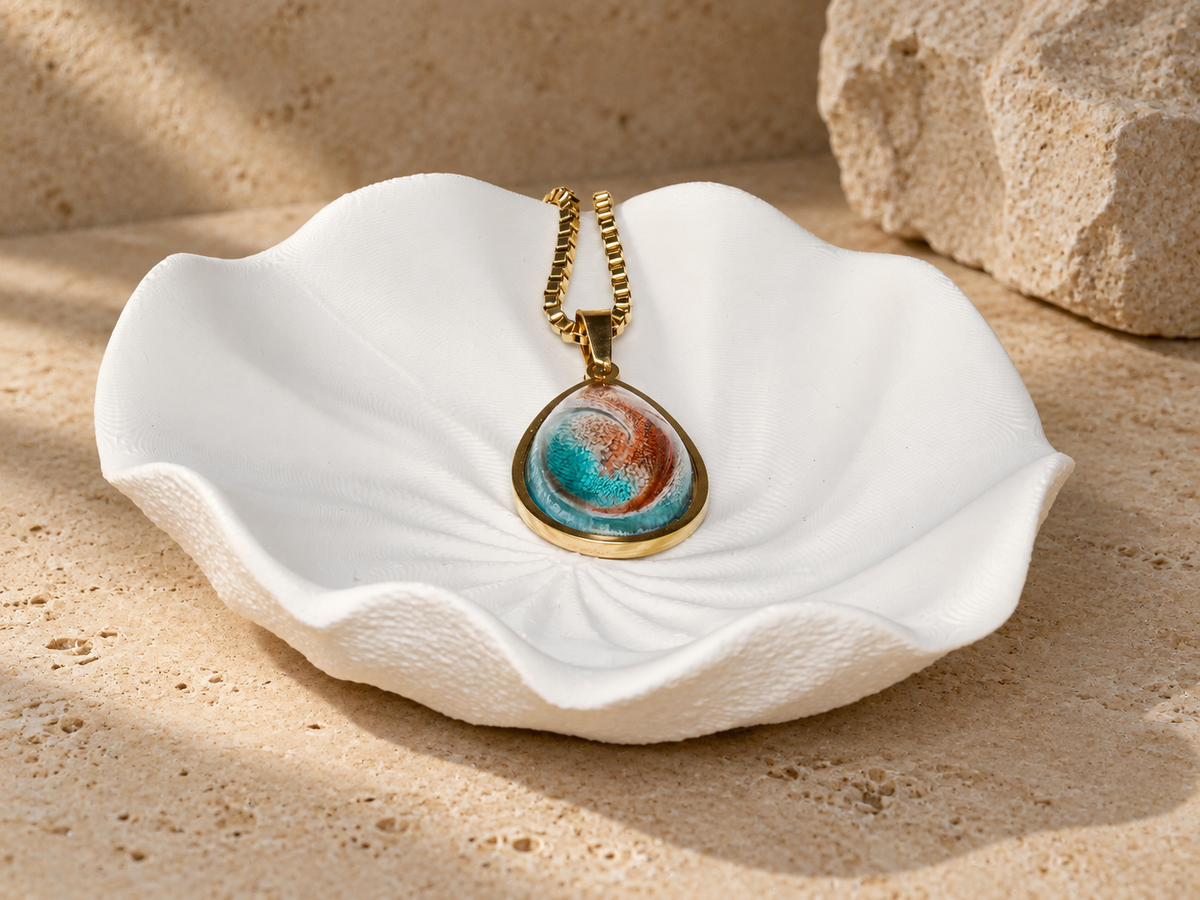 Ember Tide pendant necklace resting on a sculptural shell form