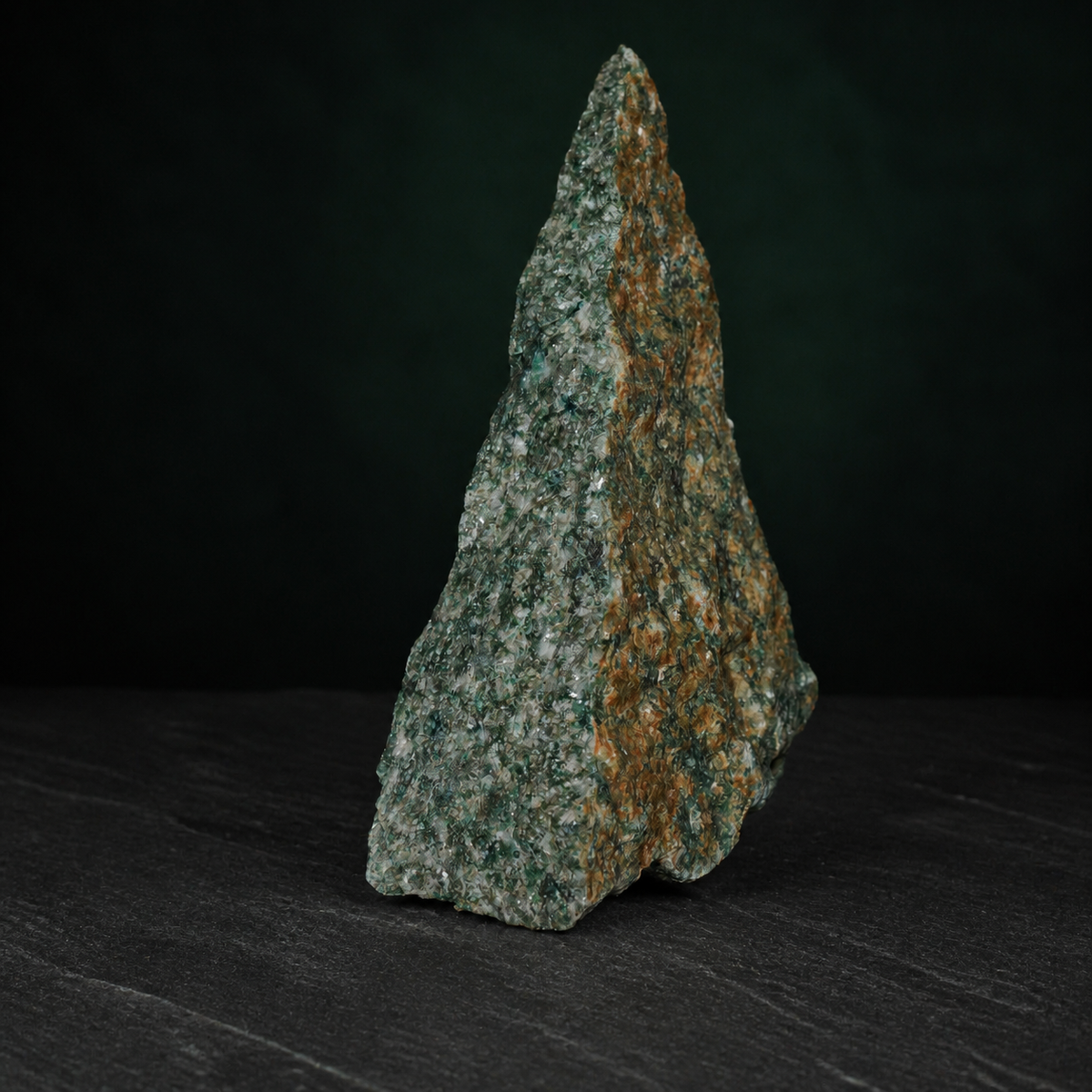 Side view of a fuchsite quartzite specimen with warm brown mineral weathering