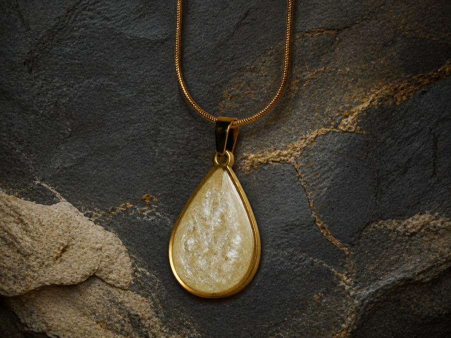 Teardrop 18K gold-plated pendant with pearlescent golden ivory resin finish on dark slate