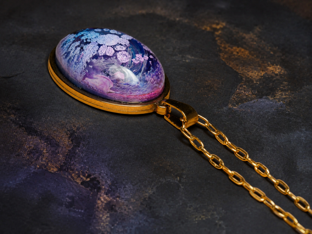 Angled close-up of the Lavender Reef oval resin pendant and gold chain on slate