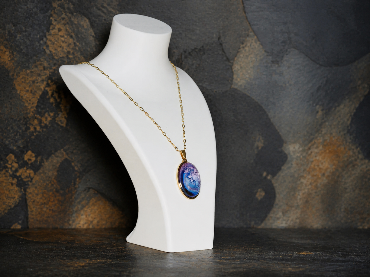 Lavender Reef oval pendant necklace on a white display bust against dark geological stone