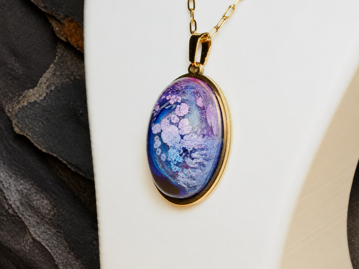 Close-up of the Lavender Reef oval pendant on a white display form with dark mineral background