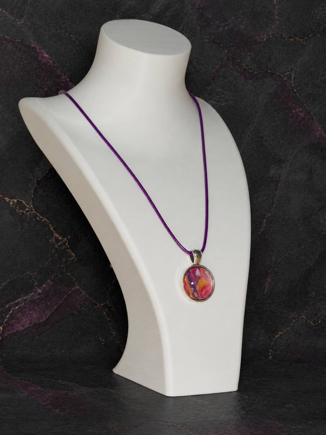 Angled display of the Magenta Strata pendant and purple cord