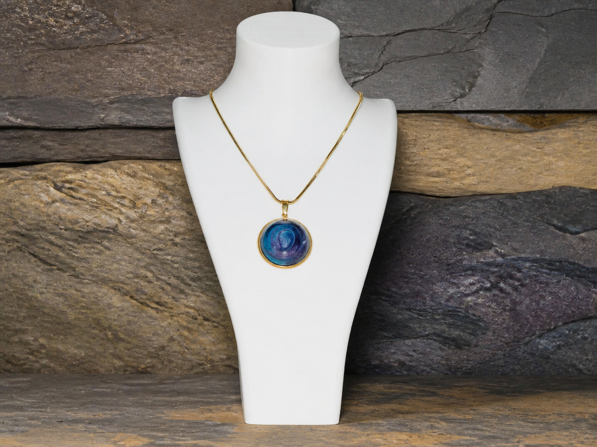 Round pendant and 45cm gold-plated chain on layered rock displayed on a bust