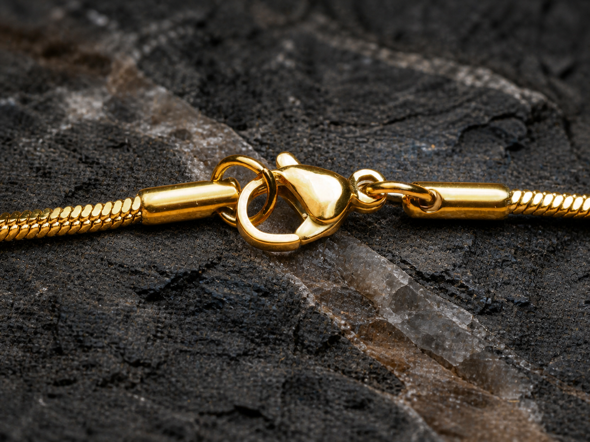 Gold-plated chain clasp on basalt with a smoky quartz vein