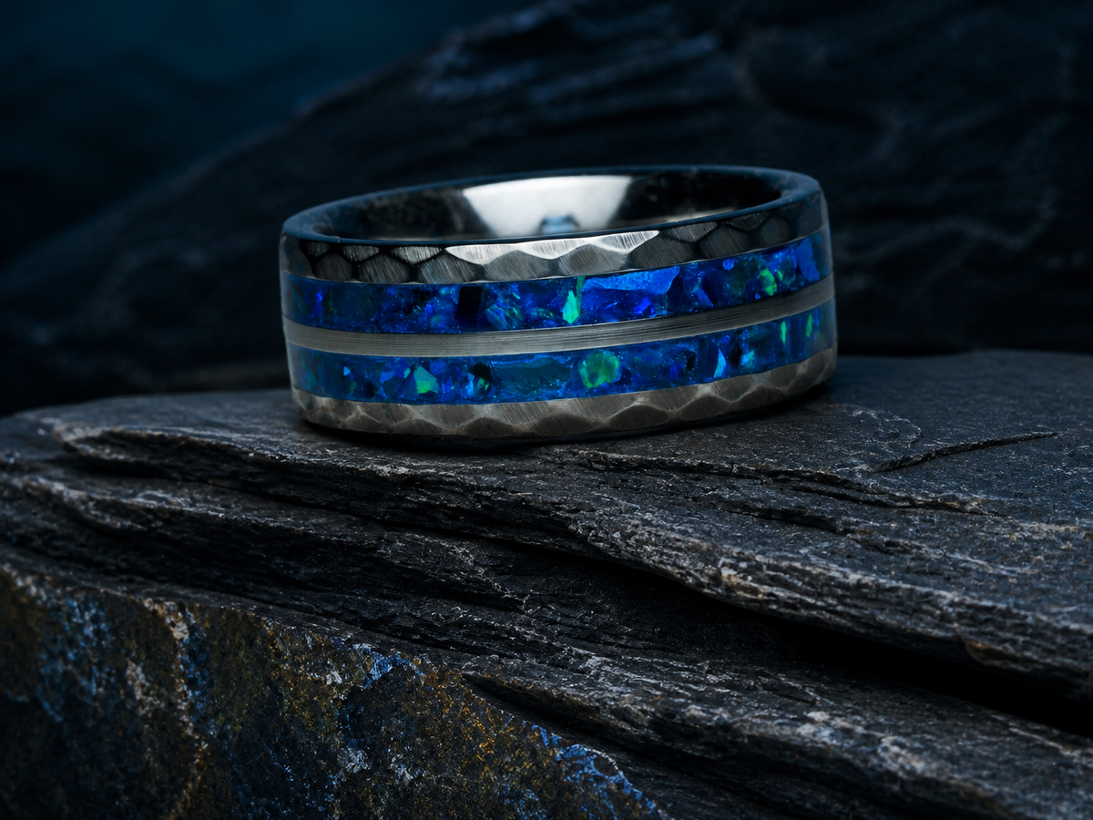 Neptune’s Anvil hammered tungsten ring with cobalt blue opal-style and apatite inlay on dark stratified slate