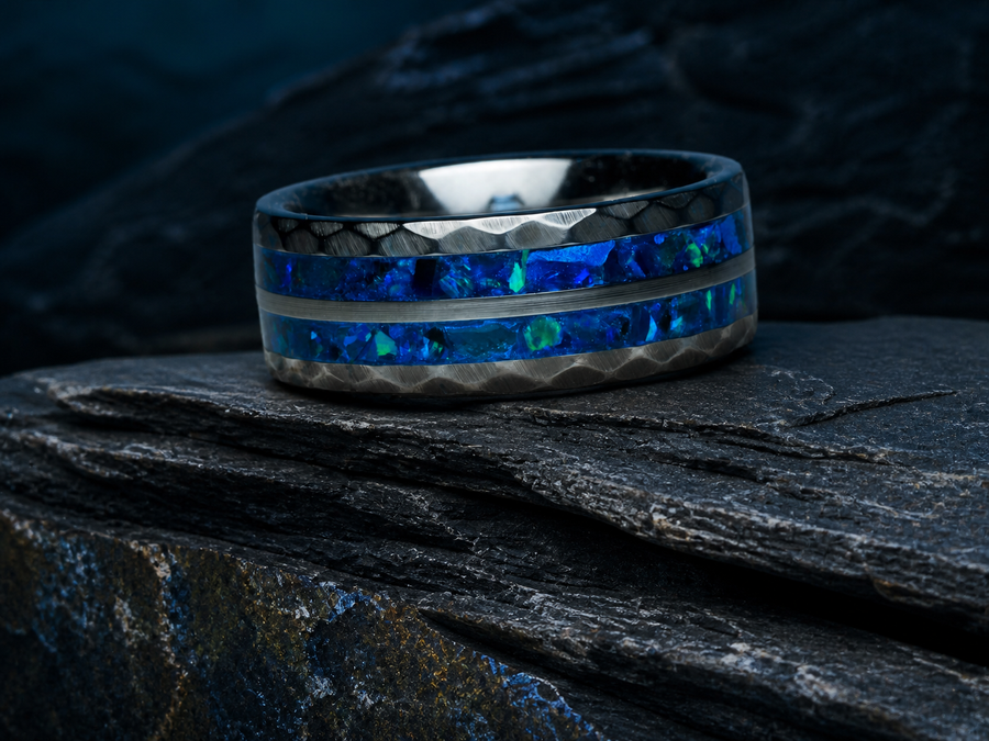 Neptune’s Anvil hammered tungsten ring with cobalt blue opal-style and apatite inlay on dark stratified slate