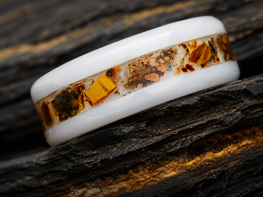 Paleogenesis white ceramic fossil inlay ring on dark stratified slate with warm mineral seams