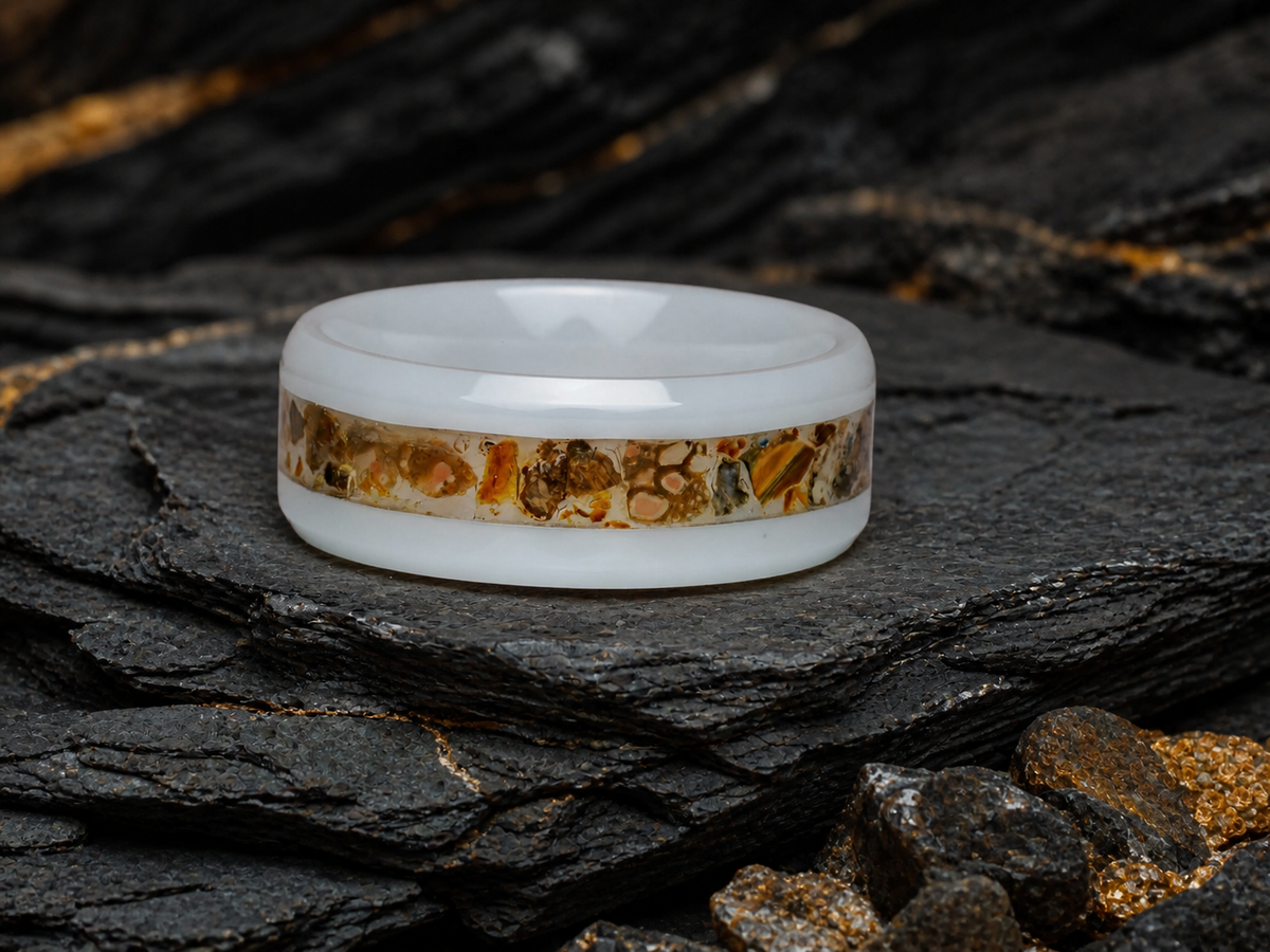 Paleogenesis white ceramic ring resting on layered charcoal slate in a deep time atelier setting