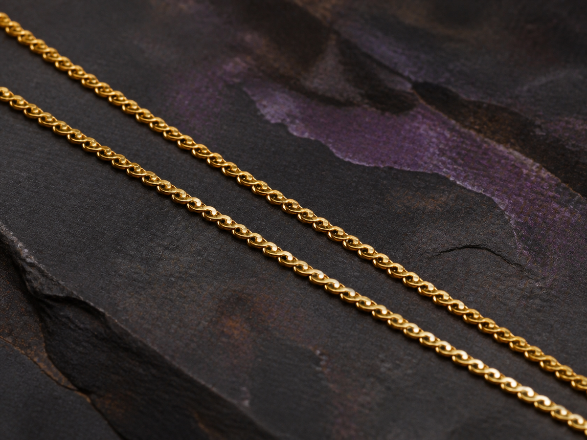 Fine gold chain detail for the Rose Tide Orbit necklace on dark slate