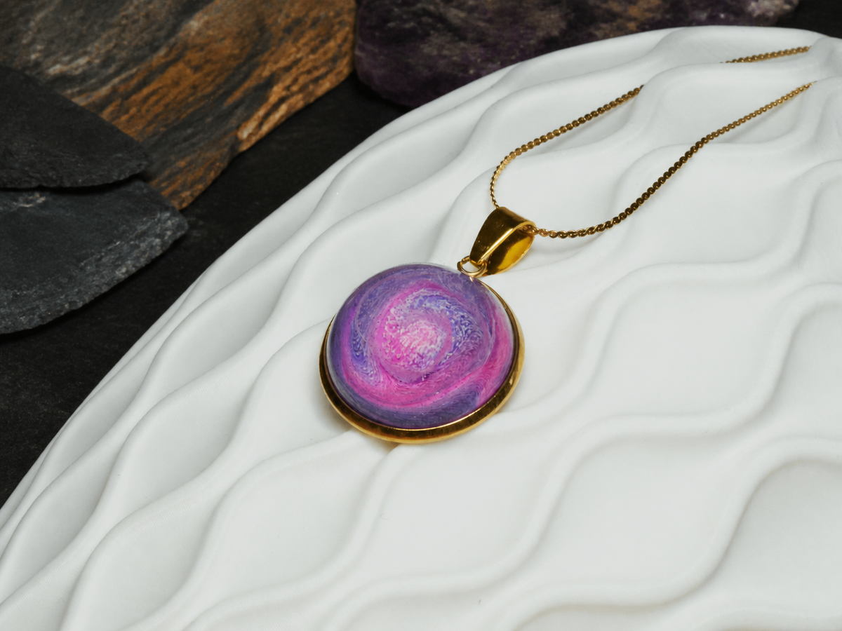Rose Tide Orbit pink and violet resin swirl pendant on white sculptural ceramic with dark mineral stone
