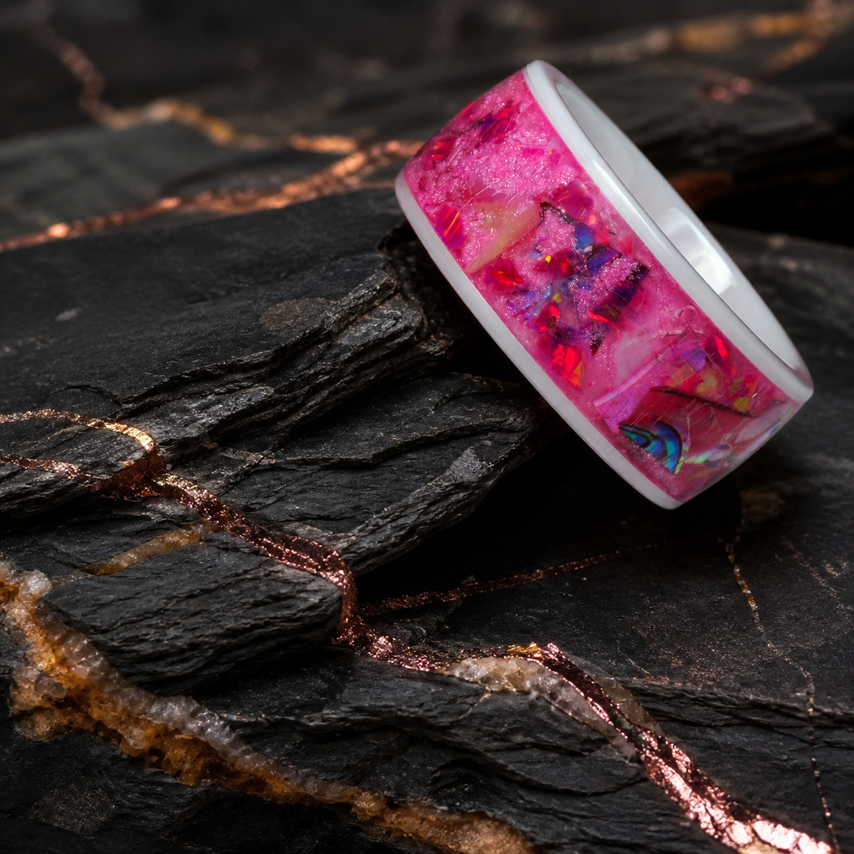 Angled Rosetide Lumina pink inlay ring on layered dark mineral stone