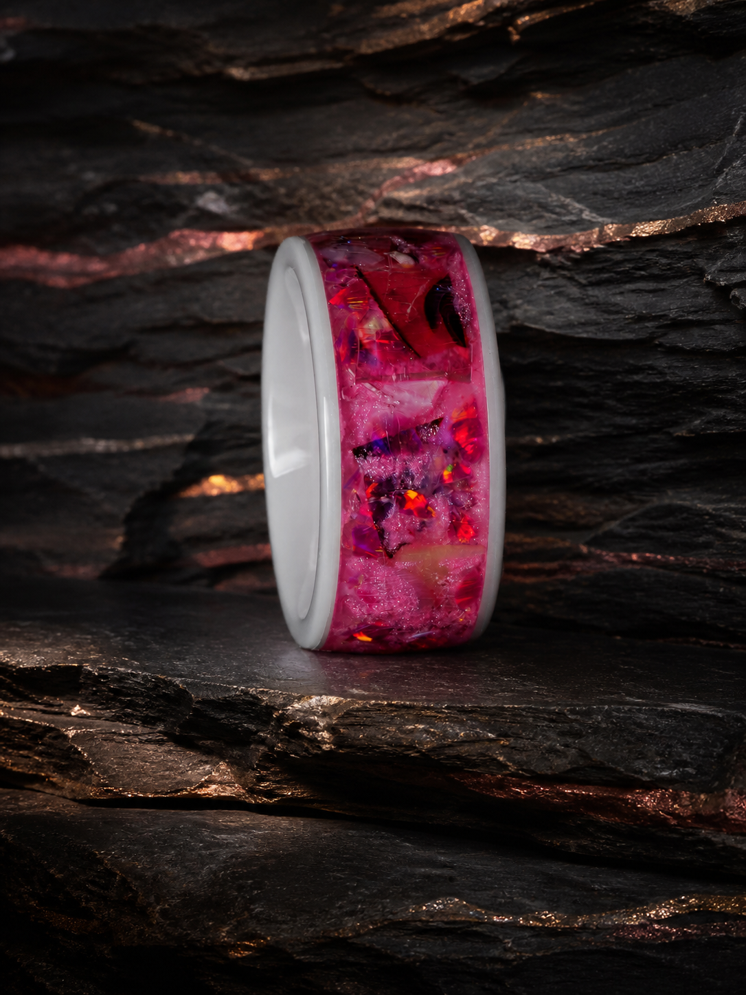 Side profile of the Rosetide Lumina pink inlay ring on dark slate