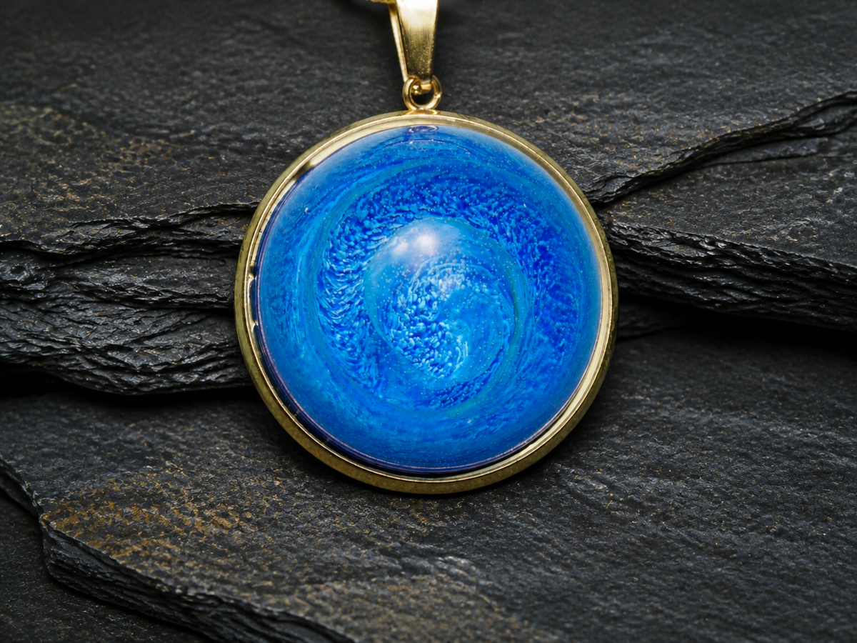 Front macro view of the Tethys Gyre pendant showing its cobalt and turquoise spiral pattern