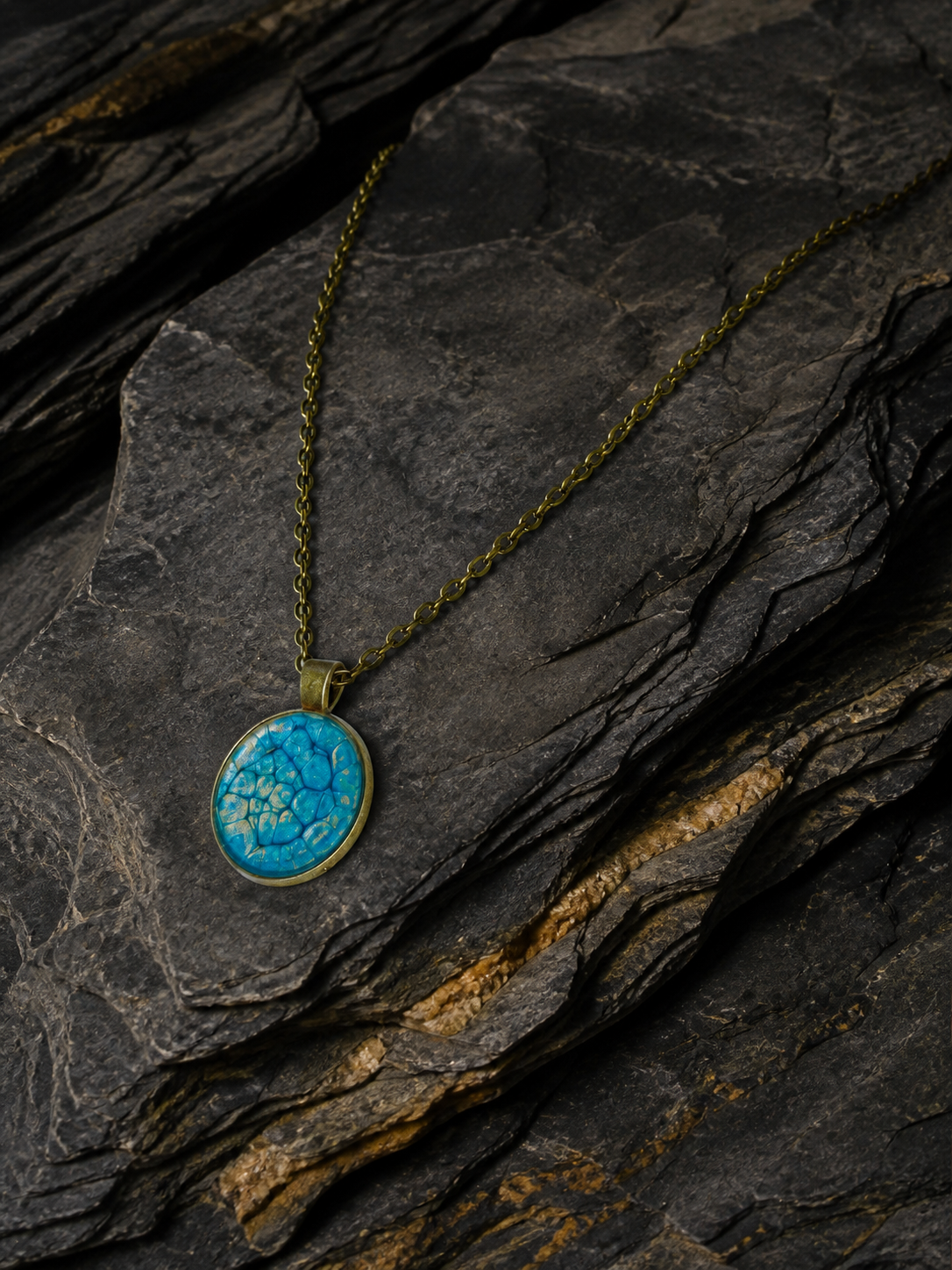 Thevenard Vein pendant necklace arranged on layered dark slate