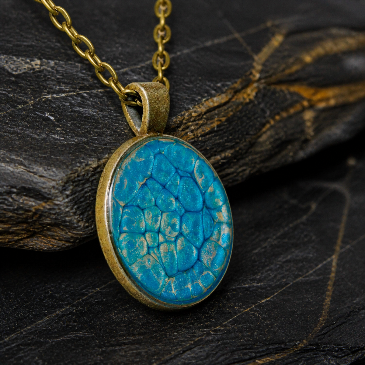 Angled close-up of the Thevenard Vein blue pendant and antique bronze bezel