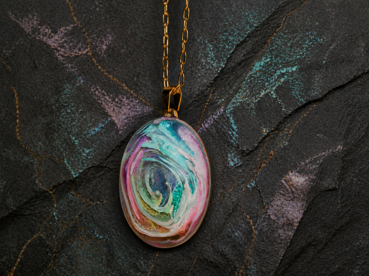 Hanging oval gold-plated pendant with multicolour resin artwork on dark mineral stone