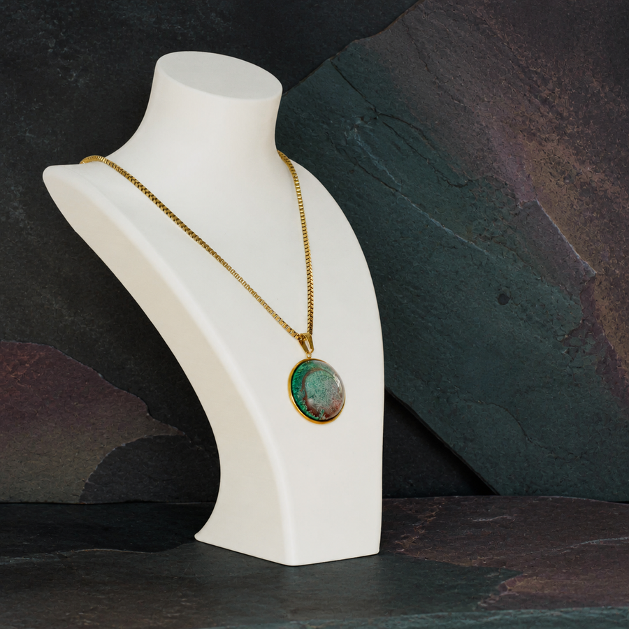 Tidal Patina 18K gold-plated round pendant necklace on a white display bust against dark mineral stone