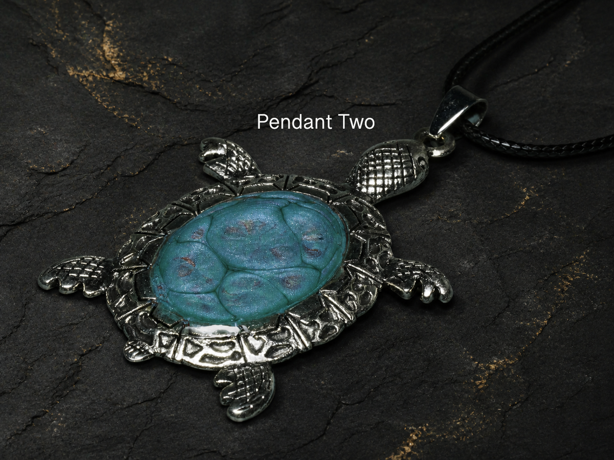 Pendant Two hand-painted turquoise turtle pendant angled detail