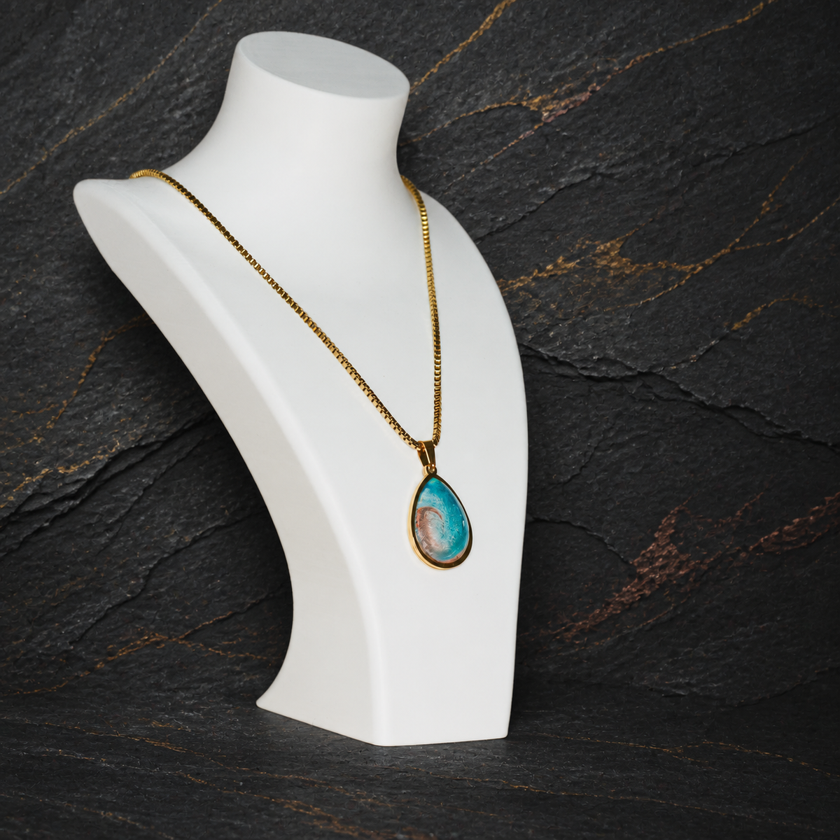 Tidal Rift pendant and 18K gold-plated box chain shown on a display bust