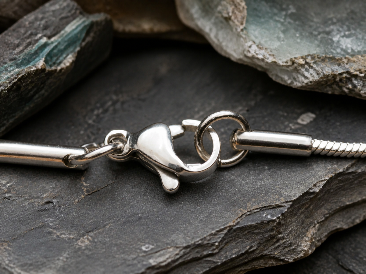 Silver plated chain clasp on dark stone with quartz and mineral textures