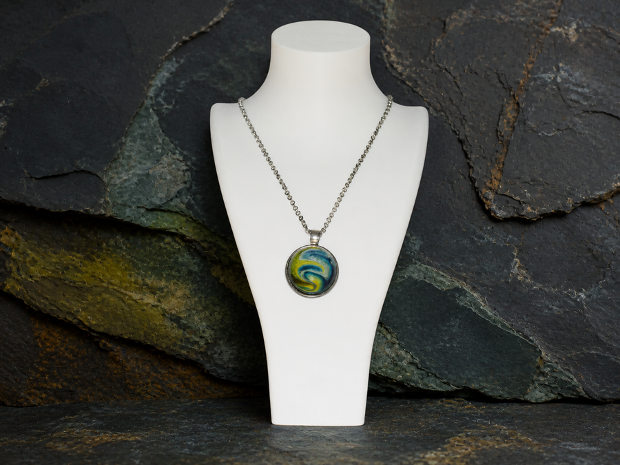Verdant Gyre silver-plated round pendant necklace on a white display bust against dark mineral stone