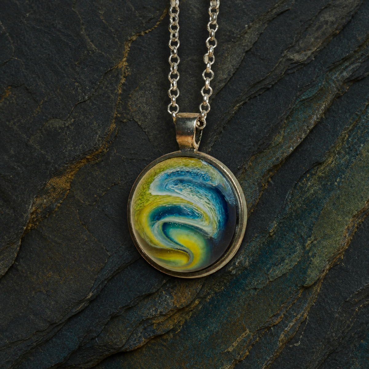 Close-up front view of the Verdant Gyre blue green and yellow resin pendant