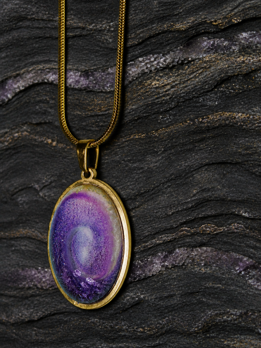 Violet Gyre oval pendant on dark folded geological stone, front view