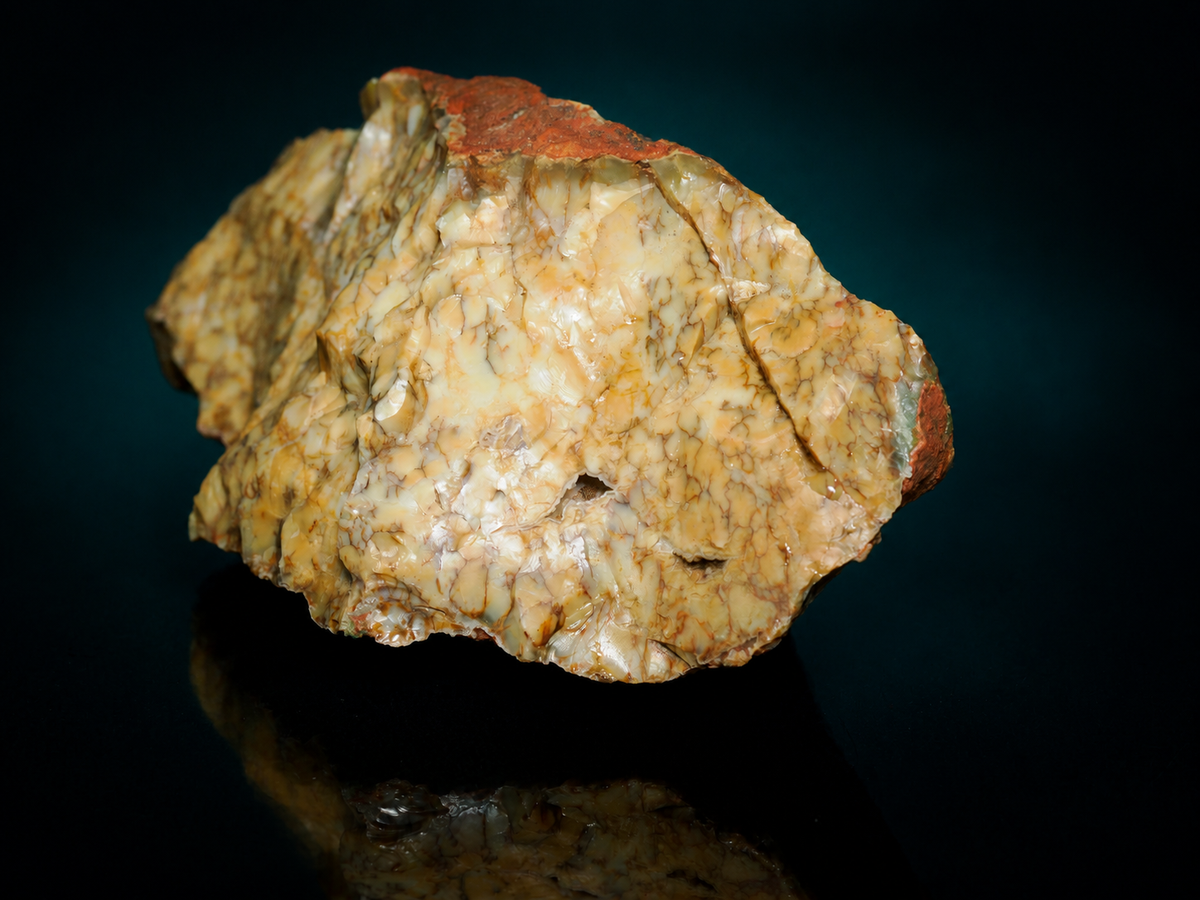 Yellow dendritic opalite specimen in red-brown matrix, angled view